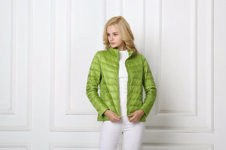 Frau in grüner Daunenjacke, Steppjacke, modisch, leicht, Damenbekleidung, Herbstmode.