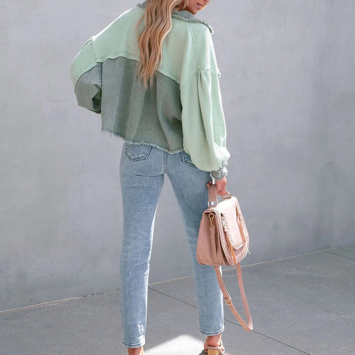 Frau in grüner Jacke und blauer Jeans mit beiger Tasche, modisch, lässig, Streetwear.