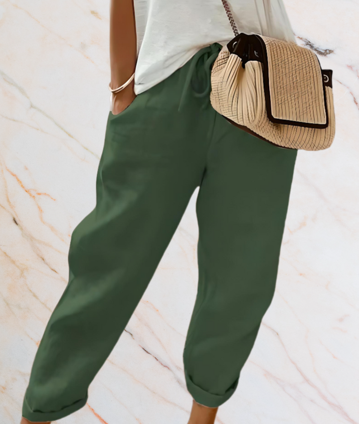 Frau mit grüner Hose und beiger Handtasche, lässiger Stil, Mode, Damenbekleidung.