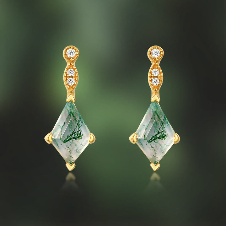Goldene Ohrringe mit grünen Edelsteinen und Diamanten, eleganter Schmuck, luxuriöses Design.