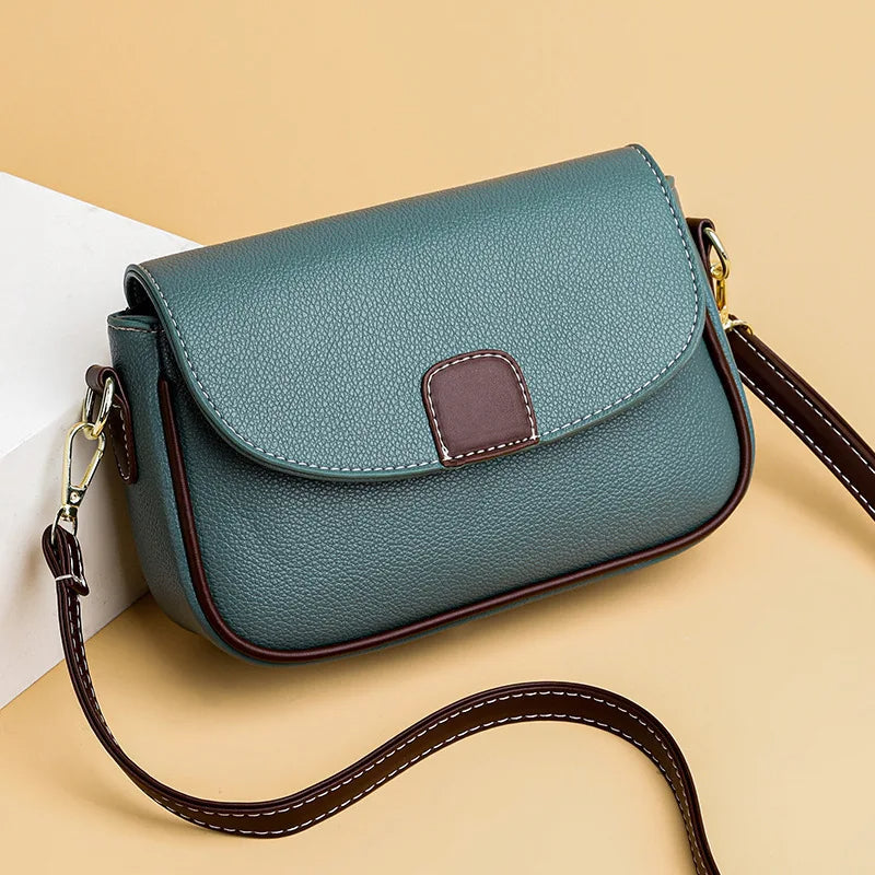 Grüne Lederhandtasche mit braunen Akzenten, Umhängetasche, modisch, elegant, Damenaccessoire.