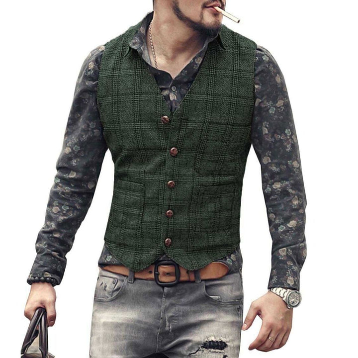 Mann in grüner Weste, gemustertem Hemd, zerrissener Jeans, mit Uhr und Tasche, rauchend.
