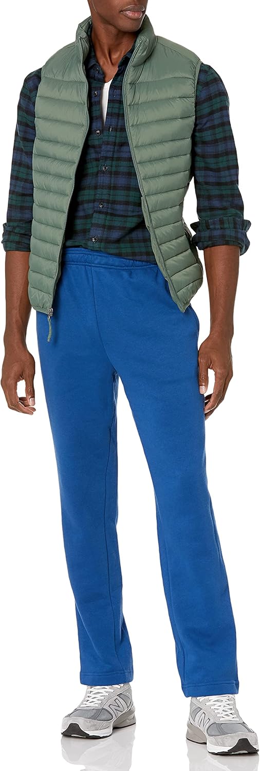 Mann in grüner Steppweste, kariertem Hemd und blauer Jogginghose, lässige Mode.