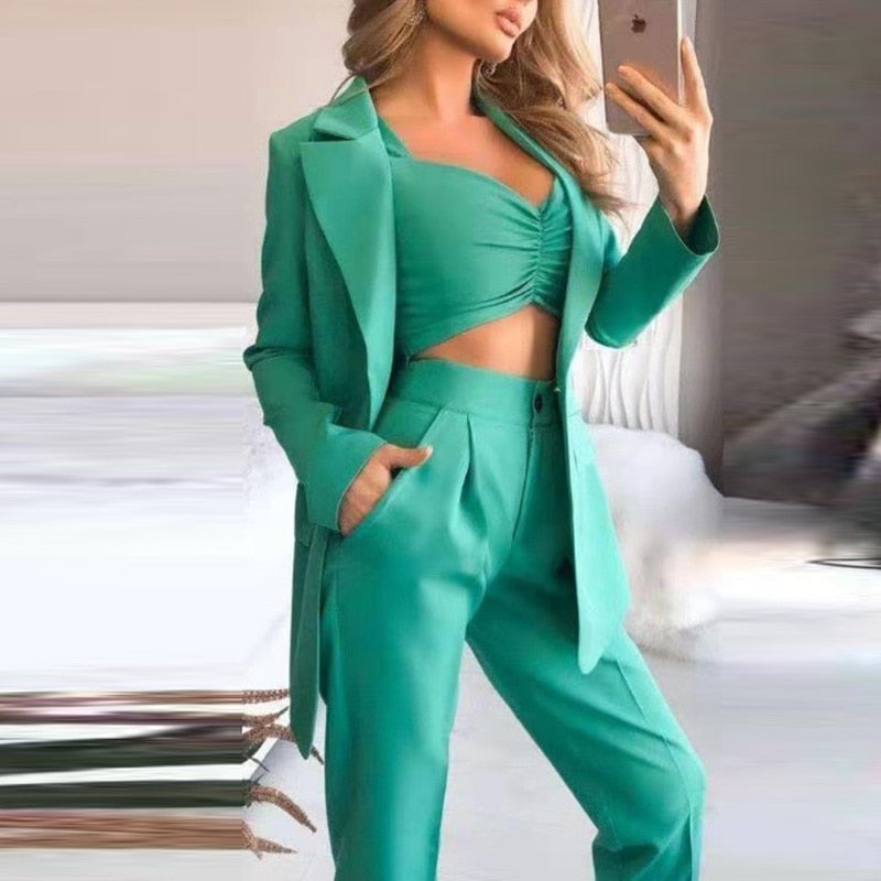 Frau in grünem Anzug mit Crop-Top, modisch, elegant, Business-Outfit, Damenmode.