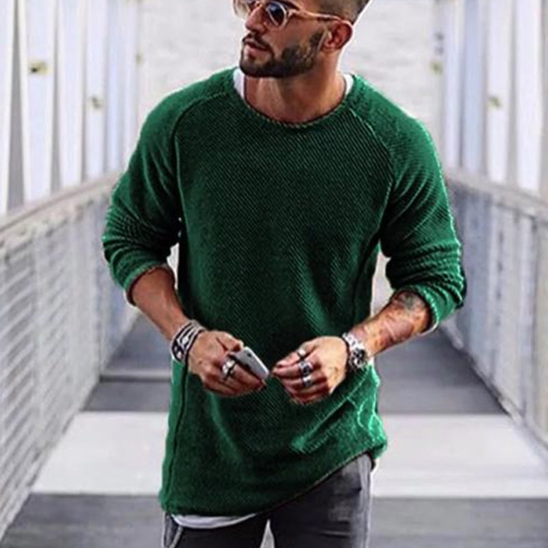 Mann mit grünem Strickpullover, Sonnenbrille, Tattoos, lässiger Stil, urbaner Hintergrund.