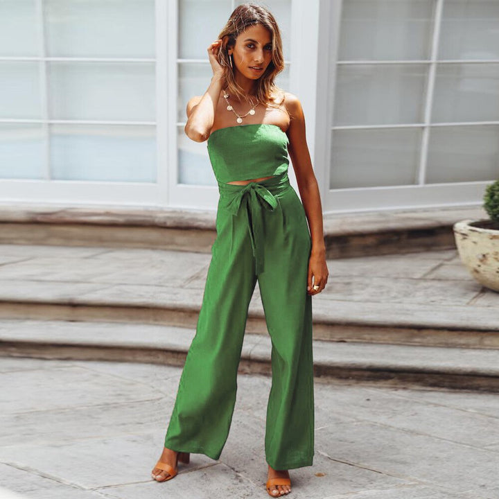 Frau in grünem Jumpsuit, ärmellos, mit Schleife, modisch, Sommerkleidung, draußen.