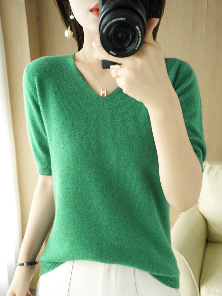 Frau in grünem V-Ausschnitt-Pullover aus Kaschmir, fotografiert mit Kamera, elegante Mode.