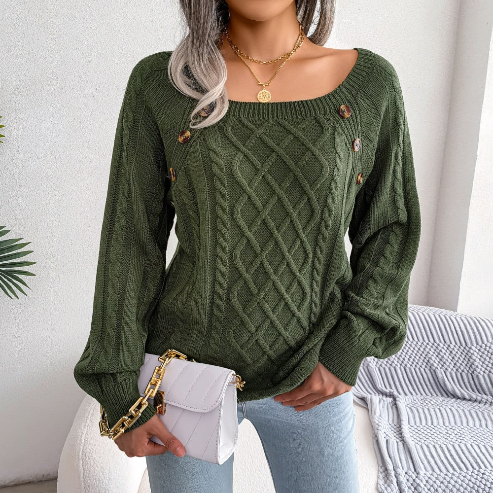 Frau trägt grünen Strickpullover mit Zopfmuster, goldene Knöpfe, weiße Umhängetasche.
