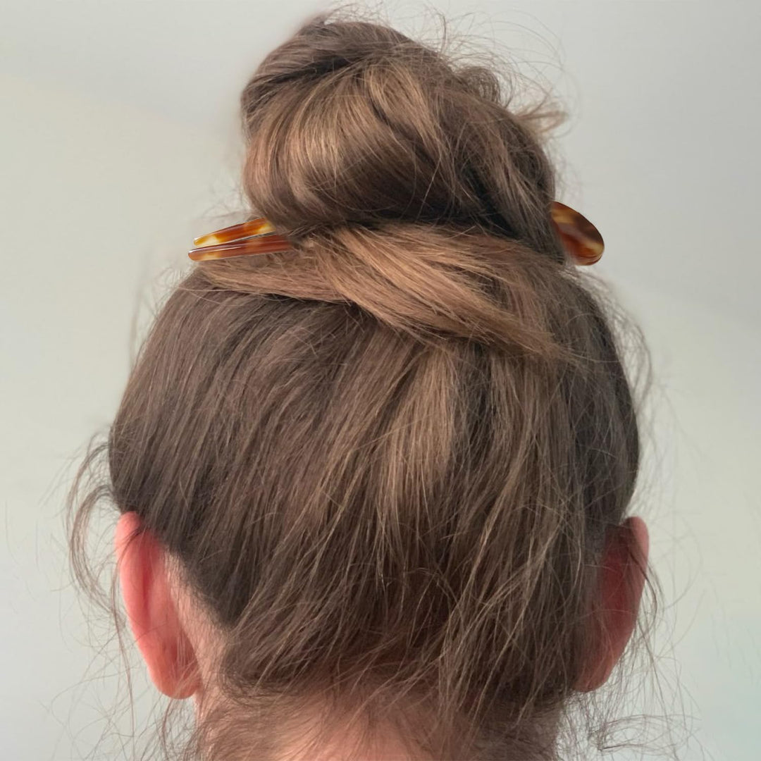 Frau mit braunem Dutt und Haarspange, Haarschmuck, Frisur, Haaraccessoire, Mode.