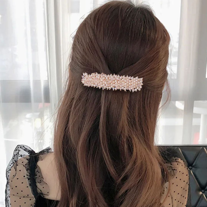 Braune Haare mit Perlen-Haarspange, elegantes Accessoire, Damenmode, Frisurentrend.