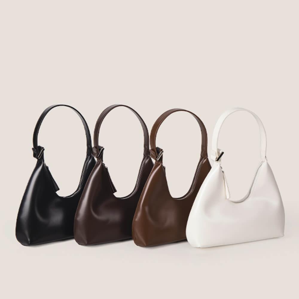 Vier tragbare Halbmondtaschen aus Leder in Schwarz, Braun und Weiß, elegant und modern.