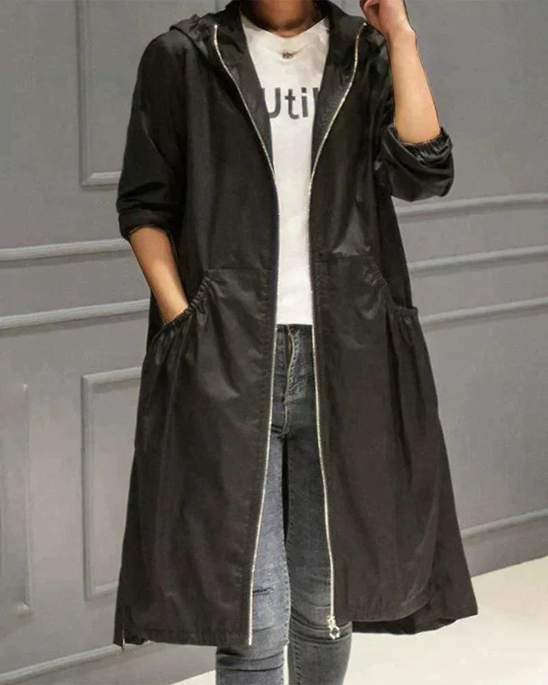 Černý plášť s kapucí a zipem na modelce s džíny, ruka v kapse 4