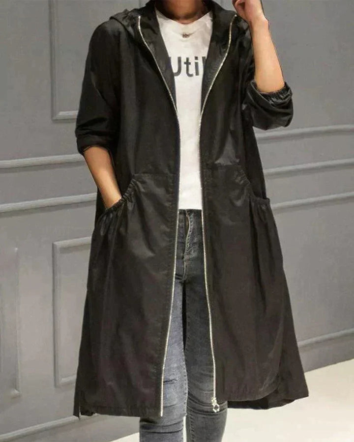 Černý plášť s kapucí a zipem na modelce s džíny, ruka v kapse 4