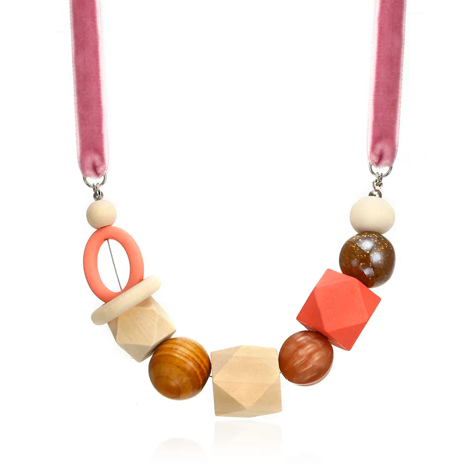 Rosa Halskette mit geometrischen Holzperlen, handgefertigt, modisch, einzigartiges Design.
