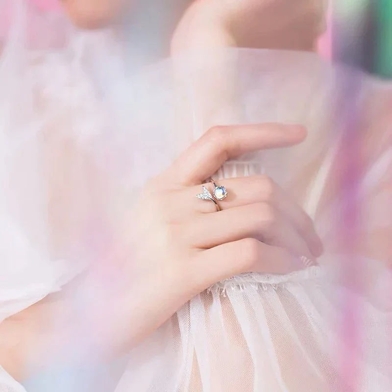 Damenhand mit Opalring und Diamanten, eleganter Schmuck, zartes Design, Hochzeitsaccessoire.