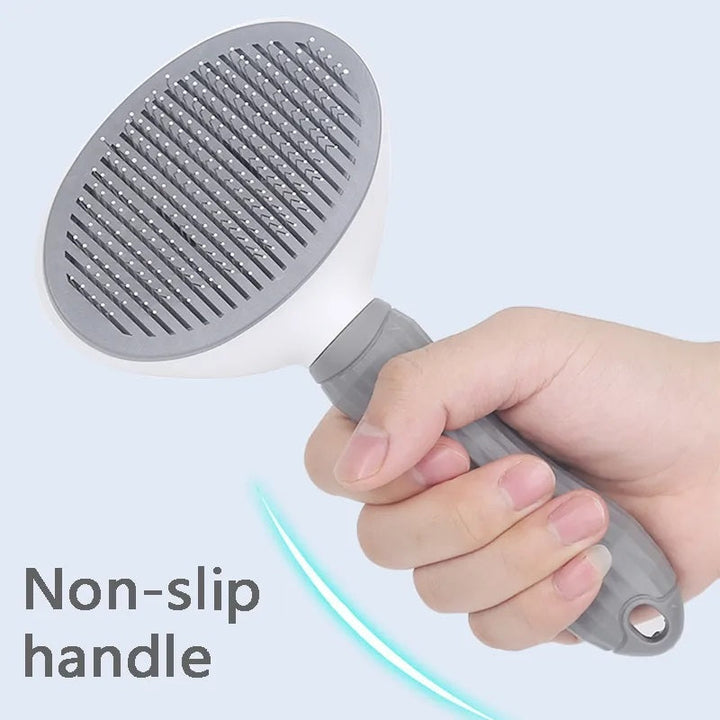 Hand hält graue Haustierbürste mit rutschfestem Griff, ideal für Fellpflege.