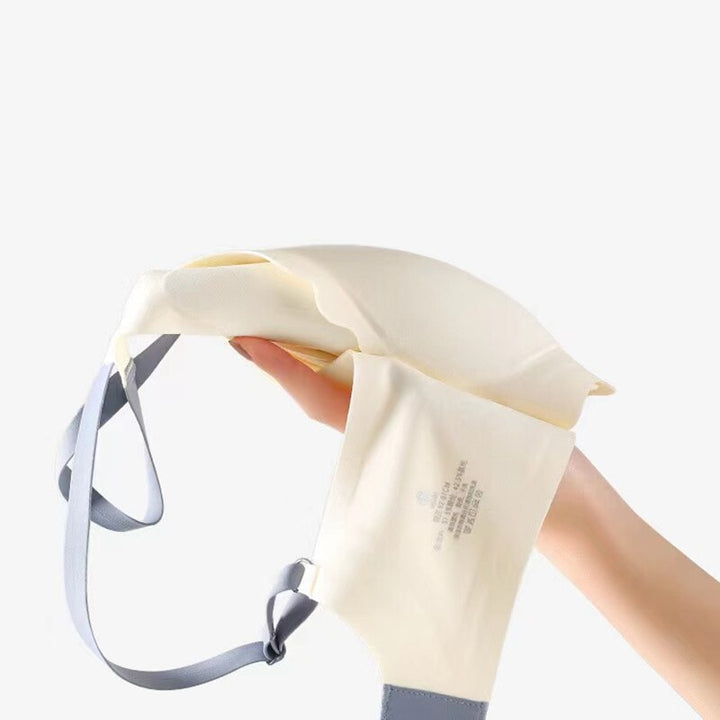 Hand hält beigen BH mit grauen Trägern, nahtlos, bequem, Damenunterwäsche.