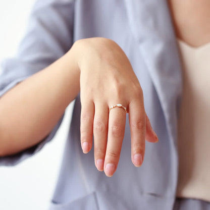 Frau mit elegantem goldenen Ring, zarte Perlen, modisches Accessoire, Nahaufnahme Hand.