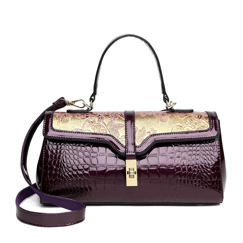 Lila Damenhandtasche aus Leder mit Blumenmuster, Krokodilprägung, goldene Details, elegant.