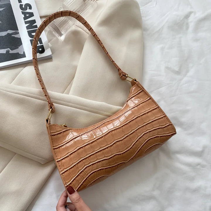 Khaki Damenhandtasche aus Krokodillederimitat, modisch, elegant, auf weißem Hintergrund.