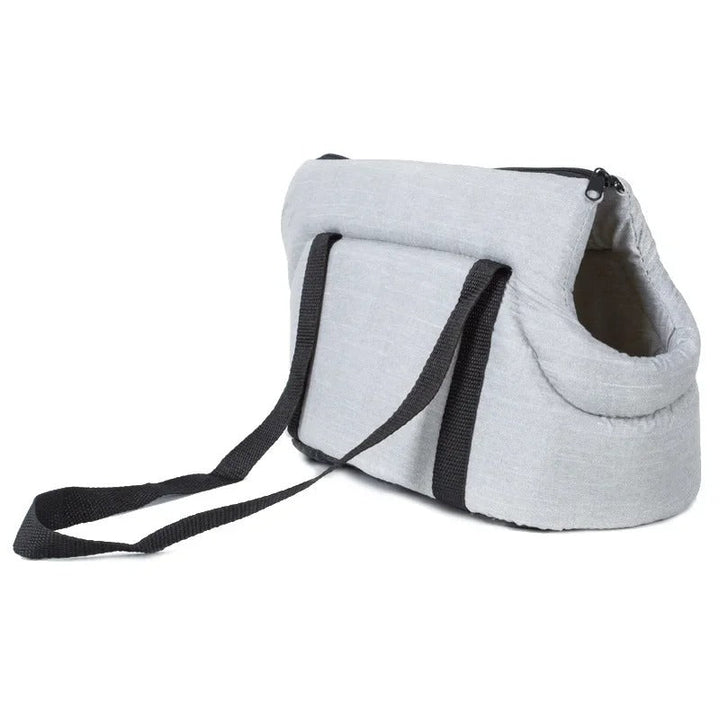 Graue Hundetragetasche mit schwarzen Trägern, ideal für kleine Hunde, aus robustem Material.