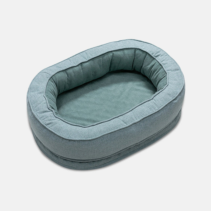 Ovales, blaues Hundebett aus Stoff, gemütlich und waschbar, ideal für kleine Hunde.