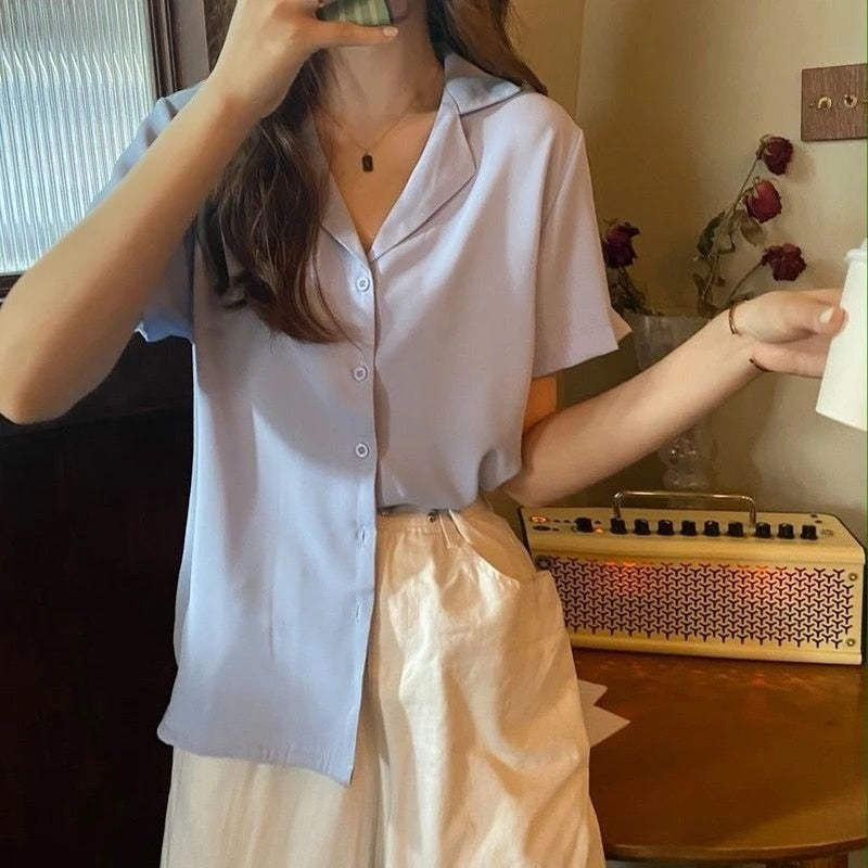 Frau in hellblauer Bluse und weißem Rock, hält Tasse, Vintage-Radio im Hintergrund.
