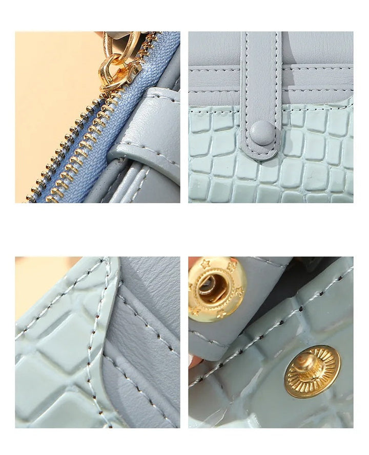 Blaue Lederhandtasche mit Krokodilleder-Textur, goldener Reißverschluss und Druckknopf.