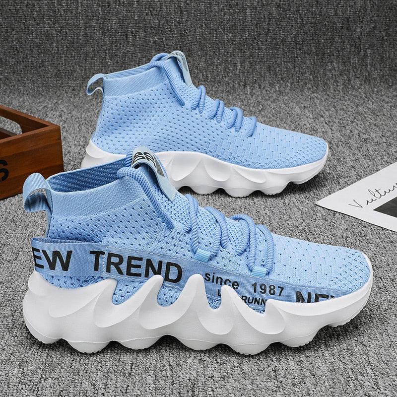 Hellblaue Sneaker mit welliger Sohle, atmungsaktivem Strickmaterial, modisch und bequem.
