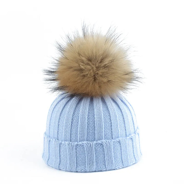 Hellblaue Strickmütze mit braunem Kunstfellbommel, Wintermode Accessoire.