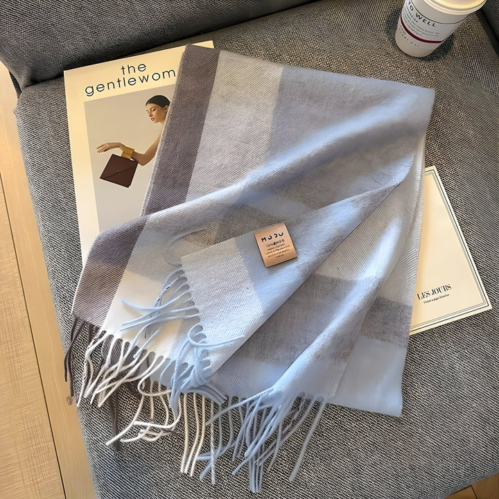 Hellblauer Kaschmirschal mit Fransen auf Zeitschrift, elegantes Accessoire, weiches Material.
