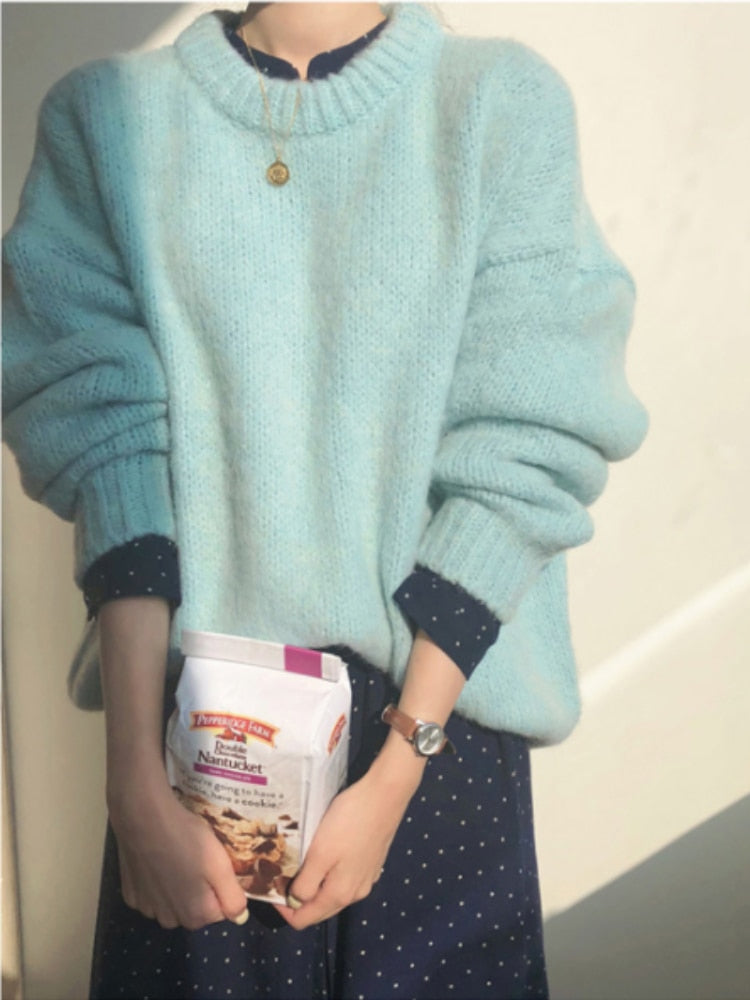 Frau in hellblauem Pullover hält Packung Haferflocken, modisch, gemütlich, Herbstmode.