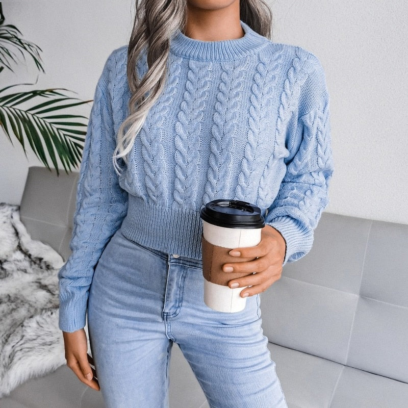 Frau in hellblauem Strickpullover mit Kaffeebecher, modische Freizeitkleidung, Wohnzimmer.