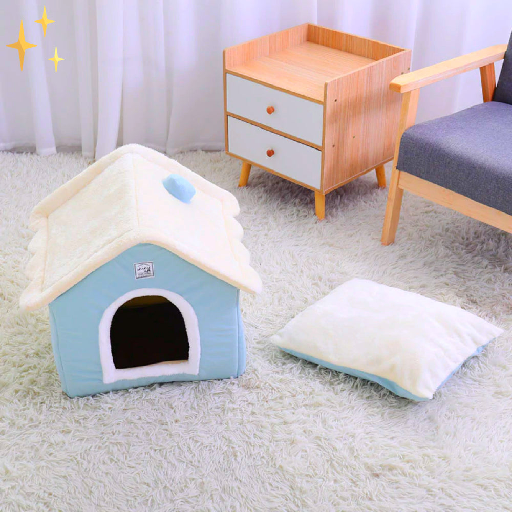 Blaue Hundehütte aus Plüsch auf Teppich, mit Kissen, ideal für kleine Haustiere.