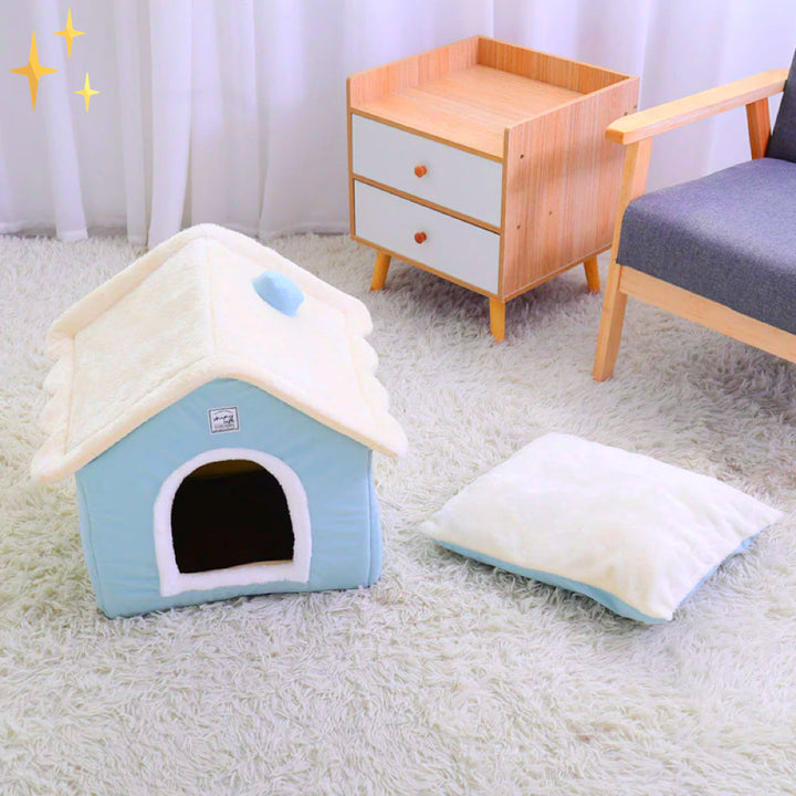Blaue Hundehütte aus Plüsch auf Teppich, mit Kissen, ideal für kleine Haustiere.