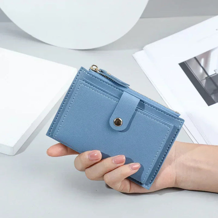 Blaue Leder-Geldbörse mit Druckknopf, handgehalten, stilvoll und kompakt für Damen.