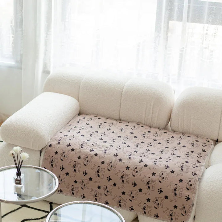 Beige Sofadecke mit Katzenmuster auf weißem Sofa, Wohnzimmer, gemütlich, modern, Dekoration.