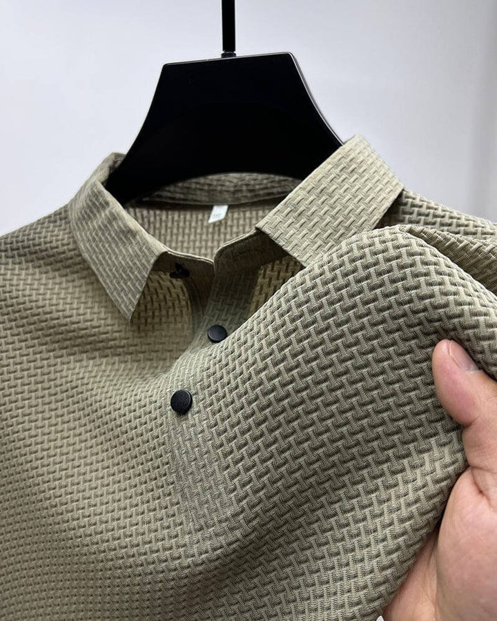 Beiges Herrenhemd mit strukturiertem Muster, Knopfleiste, elegantes Design, auf Kleiderbügel.