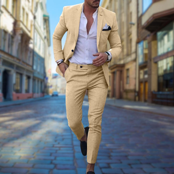Ein Mann im beigen Slim-Fit-Anzug läuft auf einer gepflasterten Straße in der Stadt.