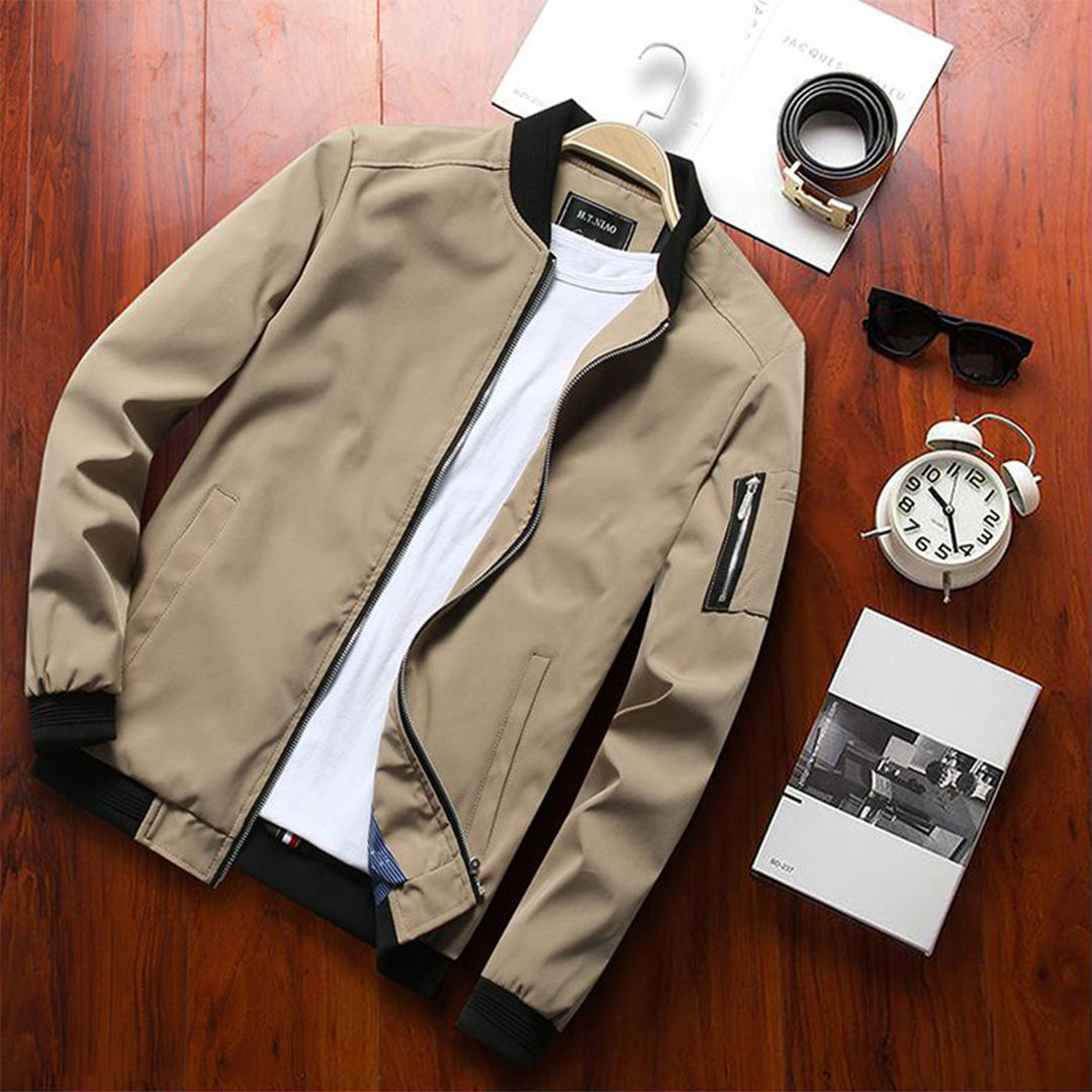 Beige Herren-Sommerjacke, kurz, stilvoll, mit Reißverschluss, auf Holztisch.