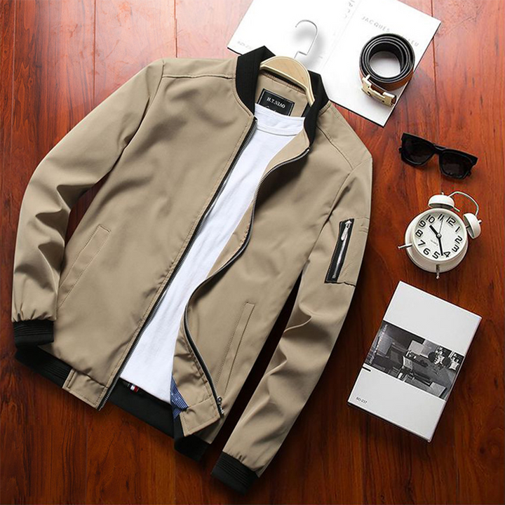 Beige Herren-Sommerjacke, kurz, stilvoll, mit Reißverschluss, auf Holztisch.