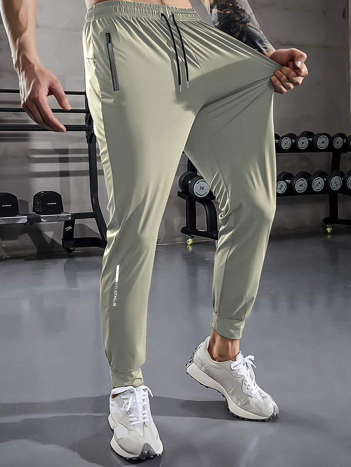 Herren Sporthose, hellgrau, mit Reißverschlusstaschen, elastisch, ideal für Fitnessstudio.