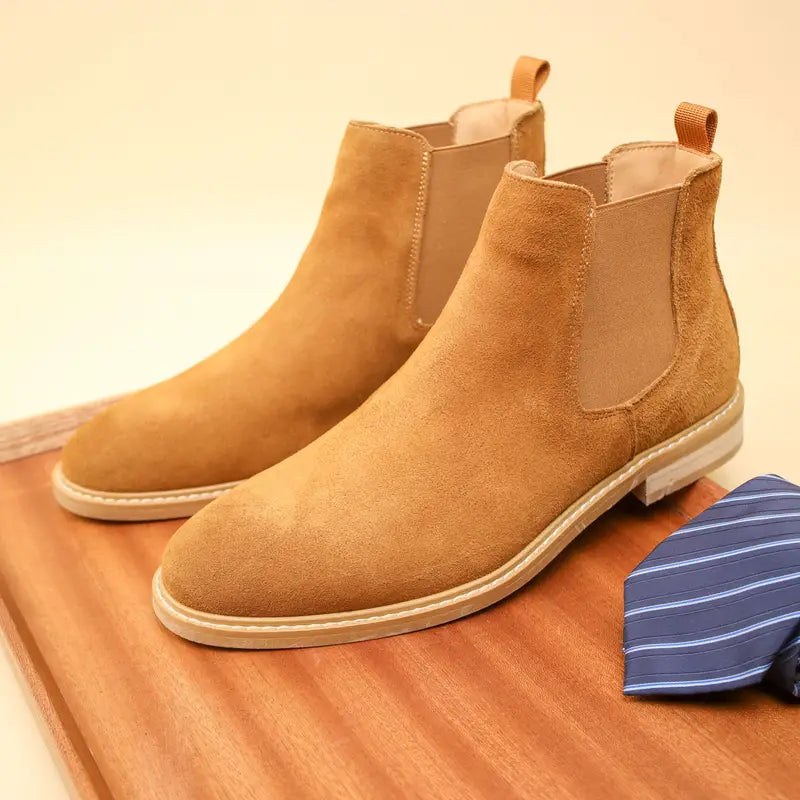 Braune Wildleder-Chelsea-Boots für Herren auf Holztablett, elegantes Design, Herbstmode.