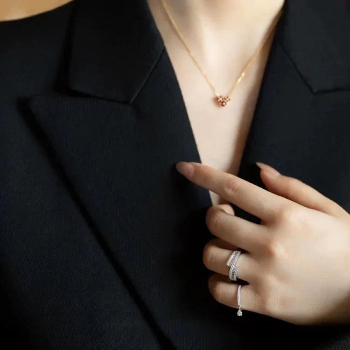 Frau mit elegantem Goldhalskette und Diamantringen, schwarzes Kleid, Schmuckmode.