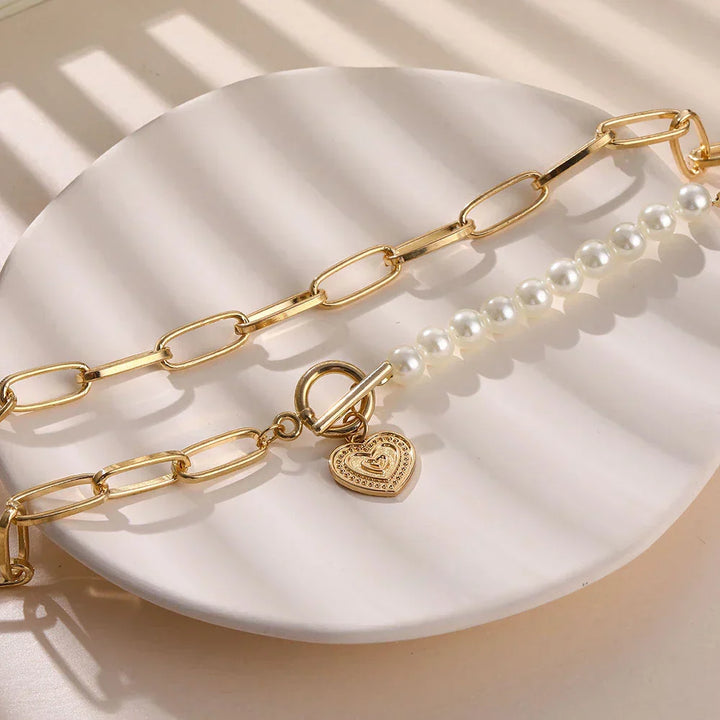 Goldene Halskette mit Herzanhänger und Perlen, modisches Schmuckstück für Damen.