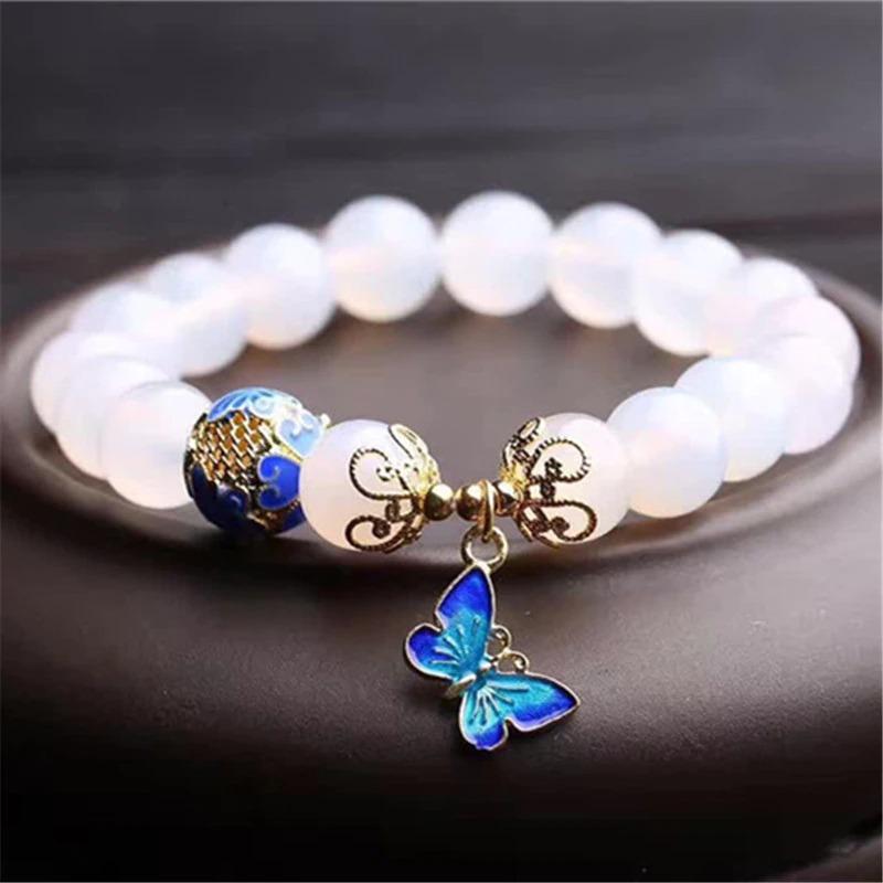Weiße Achat-Perlenarmband mit blauem Schmetterlingsanhänger, eleganter Schmuck.