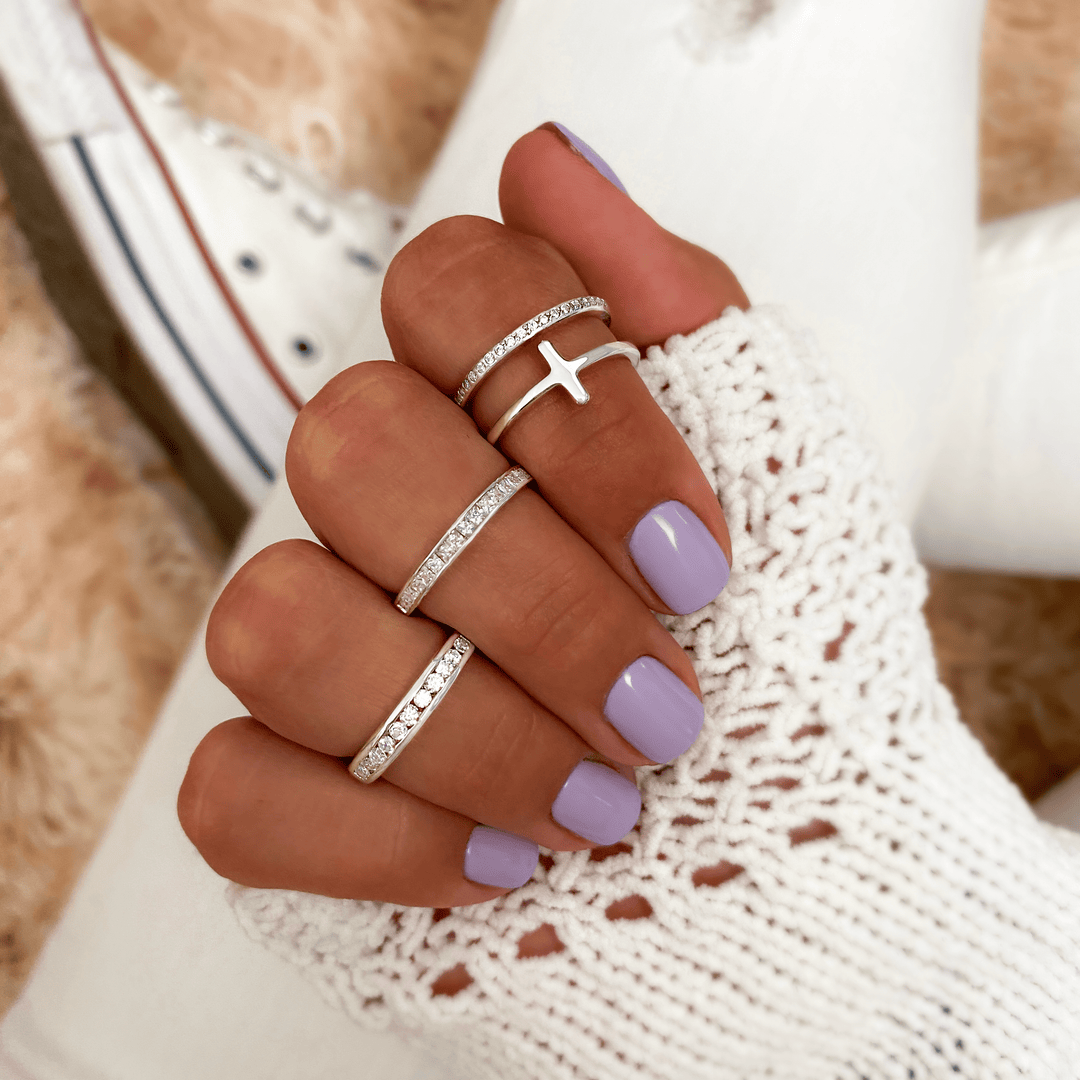 Silberringe mit Kreuzdesign, lila Nagellack, gestrickter Handschuh, Damenmode Accessoires.
