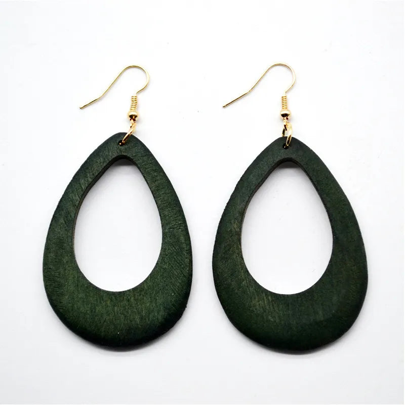 Grüne Holzohrringe, tropfenförmig, mit goldenen Haken, modisches Accessoire.
