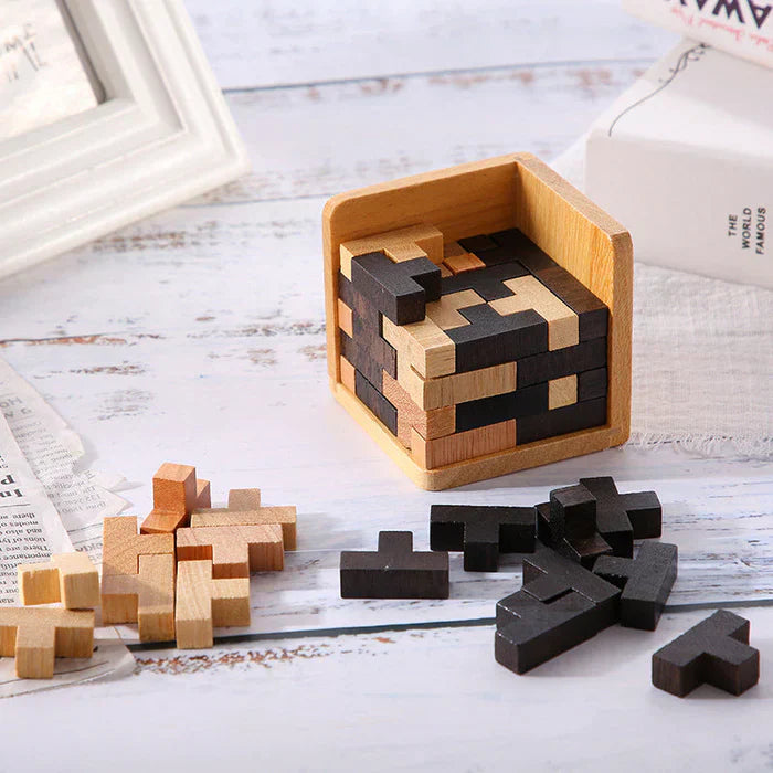 Holzpuzzle in Würfelform, schwarz und natur, auf weißem Tisch, Denkspiel, Dekoration.