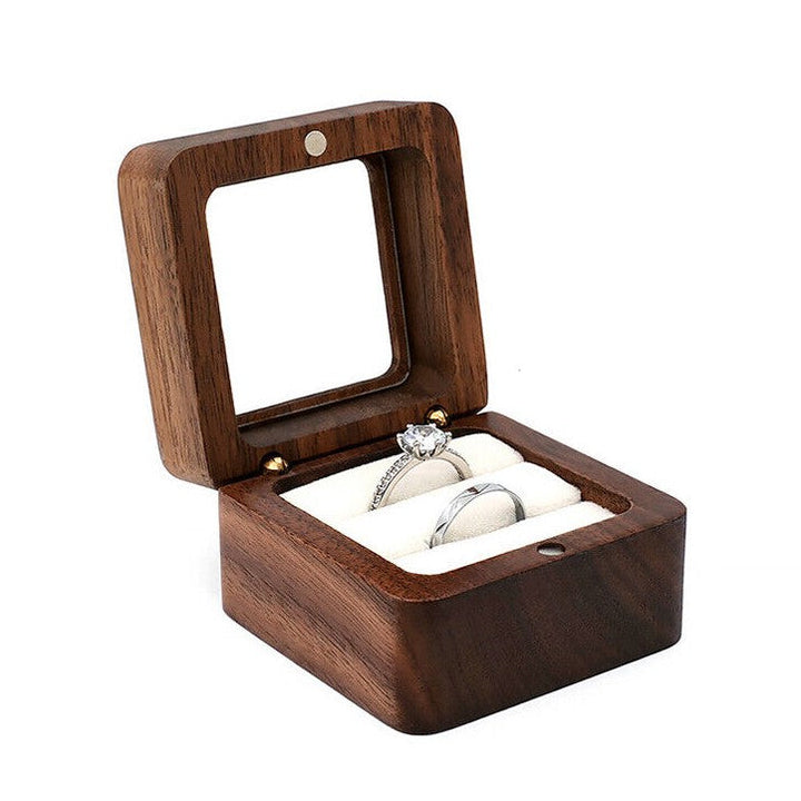 Offene Holz-Ringbox mit zwei silbernen Ringen, Verlobungsring, Schmuckaufbewahrung.
